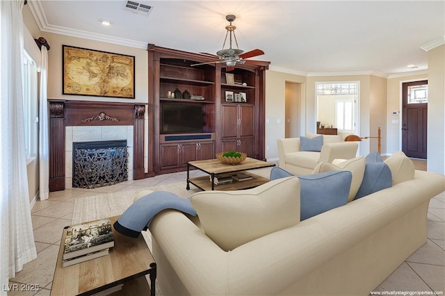 tiled living room with ceiling fan, ornamental molding, and a fireplace