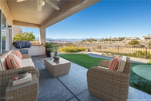 view of patio with ceiling fan, an outdoor hangout area, and a mountain view