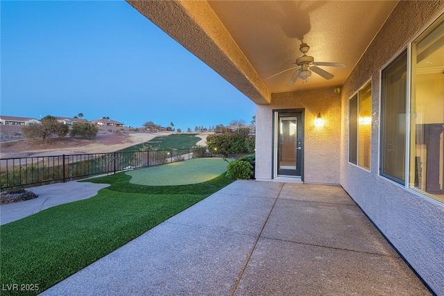 patio terrace at dusk featuring ceiling fan