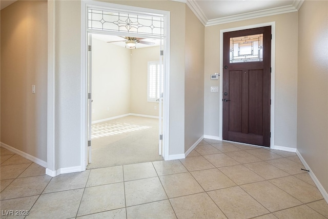 foyer entrance with ceiling fan, light tile patterned floors, and ornamental molding