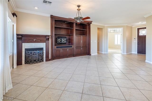 unfurnished living room with ceiling fan, light tile patterned floors, a tile fireplace, and ornamental molding