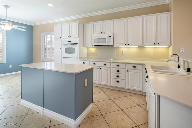 kitchen featuring ceiling fan, sink, white appliances, white cabinetry, and plenty of natural light