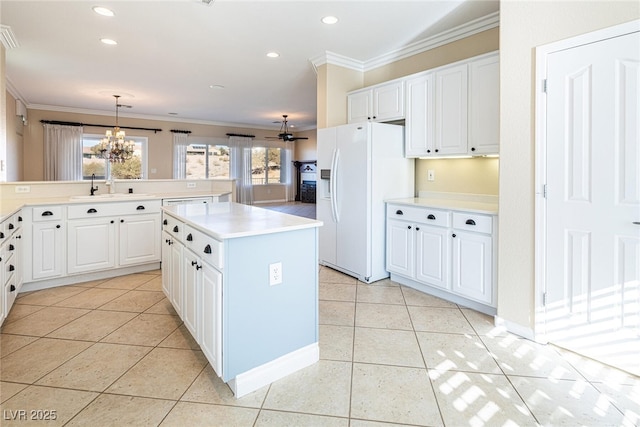 kitchen with a kitchen island, white refrigerator with ice dispenser, white cabinets, and decorative light fixtures