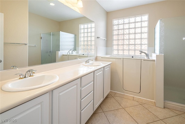 bathroom featuring a wealth of natural light, tile patterned floors, vanity, and shower with separate bathtub