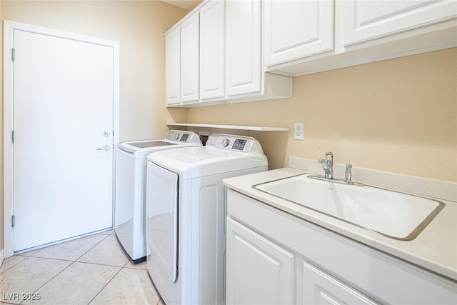 laundry area with cabinets, light tile patterned floors, independent washer and dryer, and sink