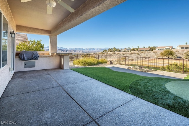 view of patio / terrace featuring ceiling fan, a mountain view, and area for grilling