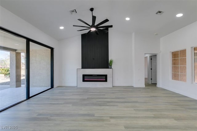 unfurnished living room featuring ceiling fan, lofted ceiling, and light hardwood / wood-style floors