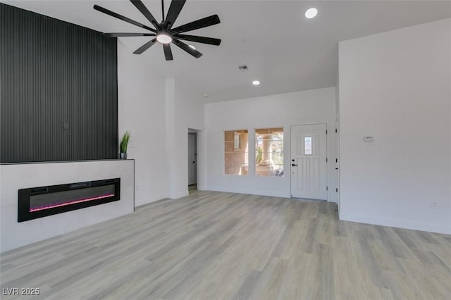 unfurnished living room with light wood-type flooring and ceiling fan