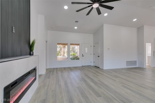 unfurnished living room featuring ceiling fan and light wood-type flooring