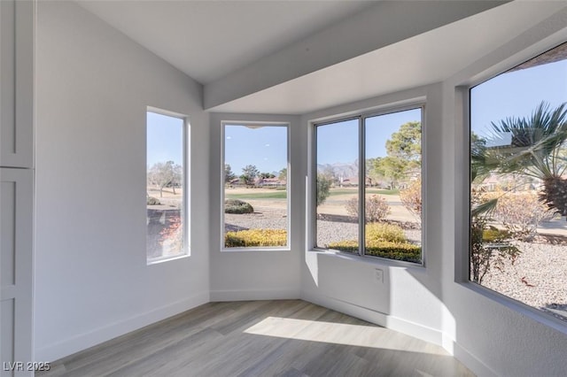 unfurnished sunroom featuring vaulted ceiling