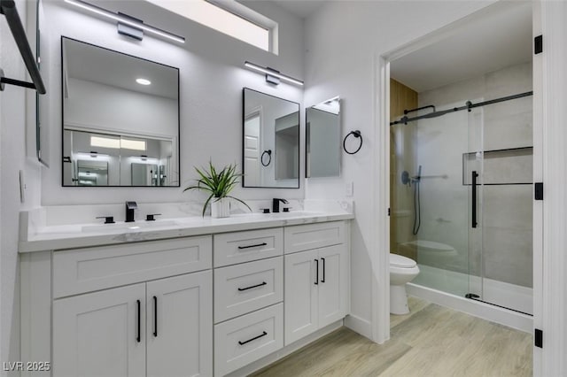 bathroom with toilet, vanity, a shower with shower door, and hardwood / wood-style flooring