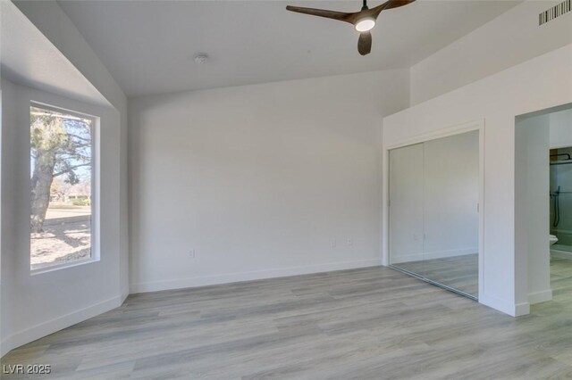 interior space featuring ceiling fan, connected bathroom, a closet, and light hardwood / wood-style flooring