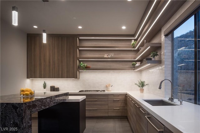 kitchen featuring pendant lighting, tile patterned floors, sink, backsplash, and stainless steel gas cooktop