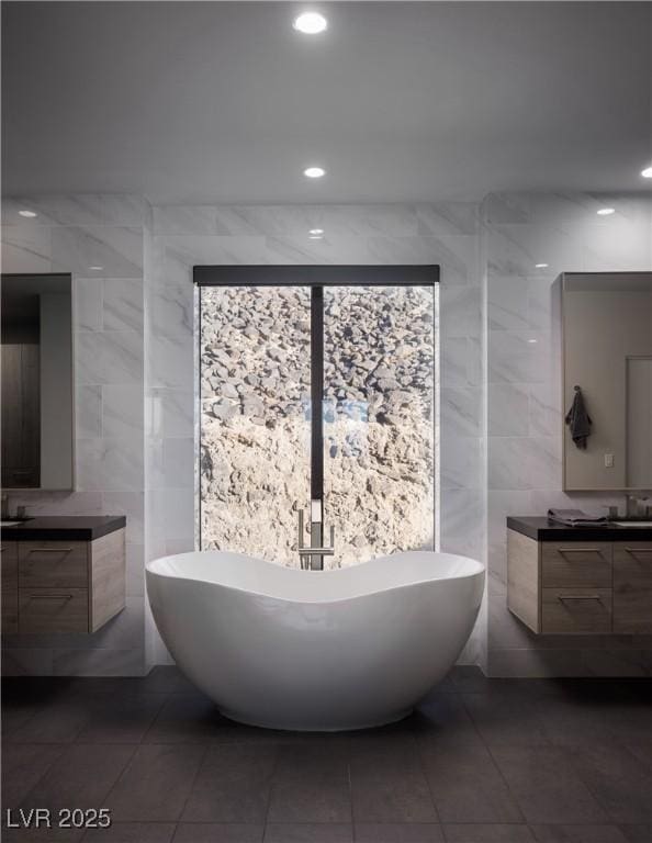 bathroom with vanity, tile walls, and a washtub