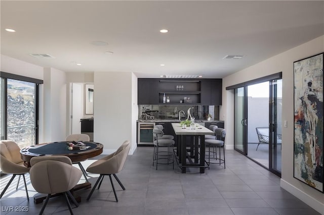 tiled dining space featuring bar area and beverage cooler