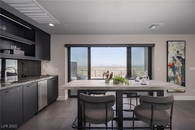 kitchen with stainless steel dishwasher, a wealth of natural light, sink, and tasteful backsplash