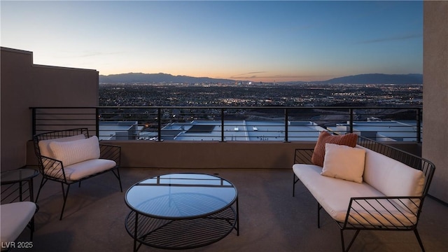 balcony at dusk featuring a mountain view and an outdoor living space