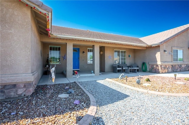 view of exterior entry featuring a patio area