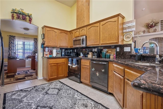 kitchen with high vaulted ceiling, sink, light tile patterned floors, and stainless steel appliances