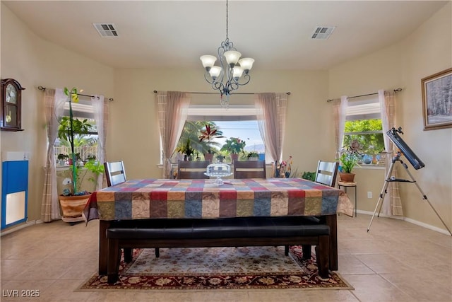 dining room featuring a notable chandelier, plenty of natural light, and light tile patterned flooring