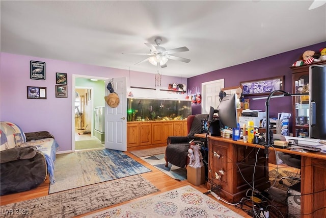 home office featuring light wood-type flooring and ceiling fan