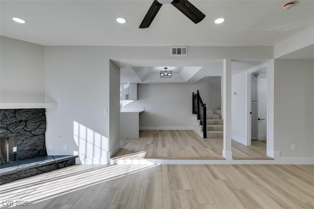 interior space featuring light hardwood / wood-style floors, ceiling fan, and a fireplace