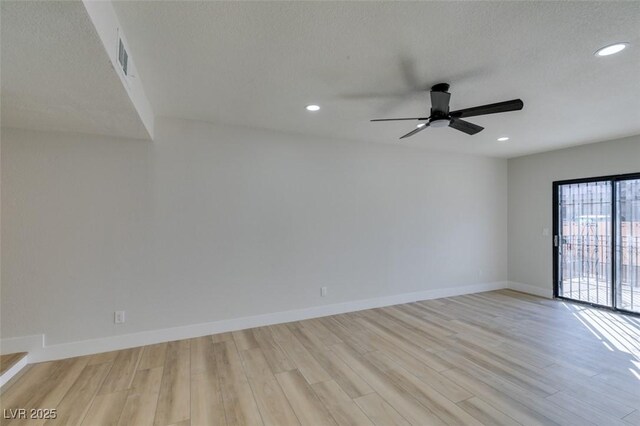 spare room with ceiling fan, light hardwood / wood-style floors, and a textured ceiling