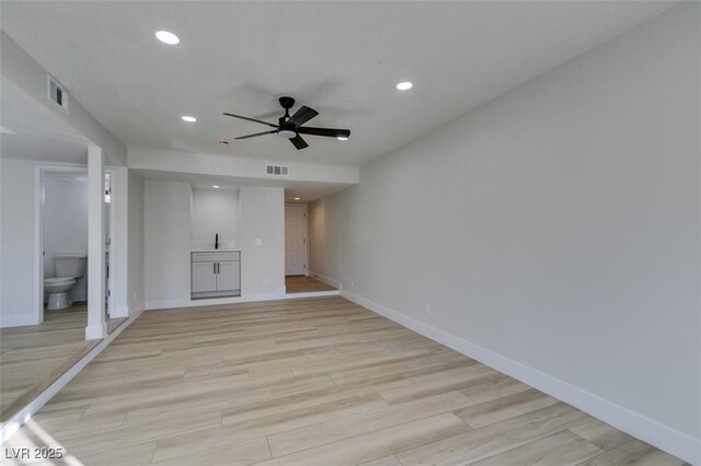 unfurnished living room featuring light wood-type flooring and ceiling fan