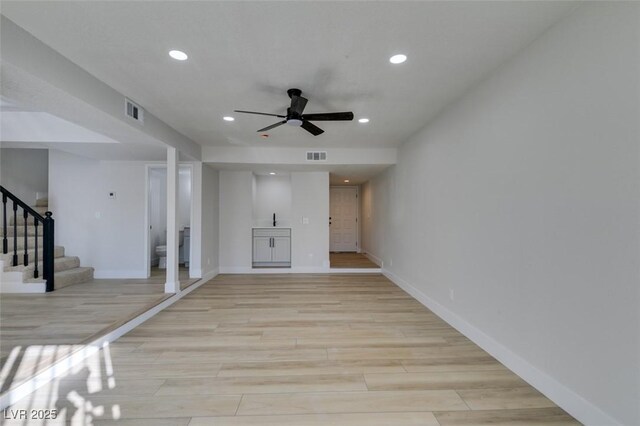 unfurnished living room with ceiling fan and light wood-type flooring