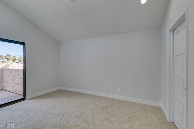 unfurnished bedroom featuring lofted ceiling and light colored carpet