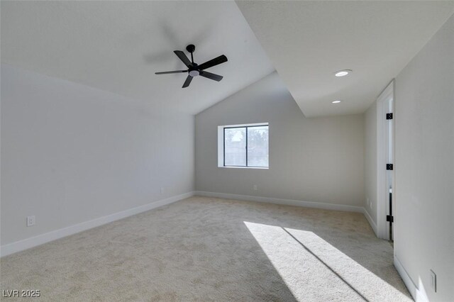 carpeted empty room featuring ceiling fan and vaulted ceiling