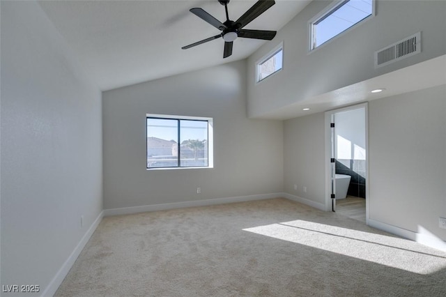 carpeted spare room featuring ceiling fan and high vaulted ceiling