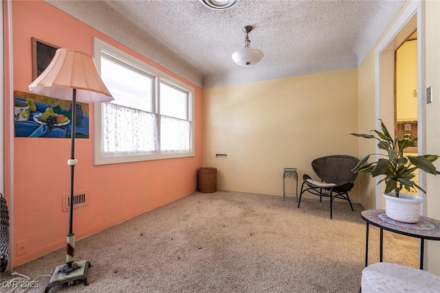 living area featuring carpet floors and a textured ceiling