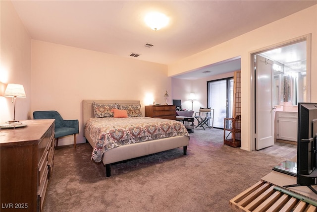 bedroom with connected bathroom and carpet flooring