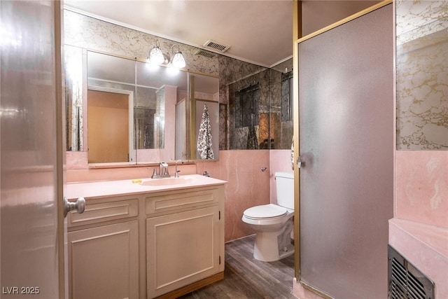 bathroom featuring vanity, toilet, hardwood / wood-style floors, and walk in shower