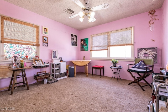 interior space featuring a textured ceiling, ceiling fan, and carpet flooring