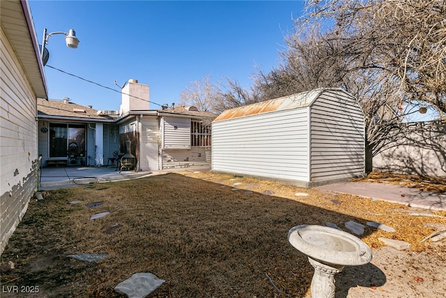 view of yard featuring a patio and a storage unit