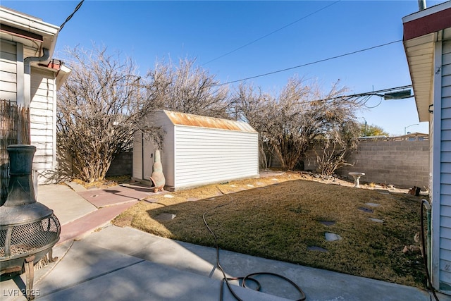 view of yard with a storage shed and a patio