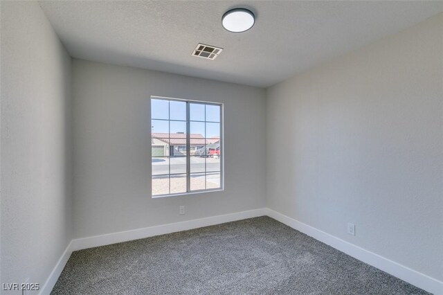 spare room with a textured ceiling and carpet