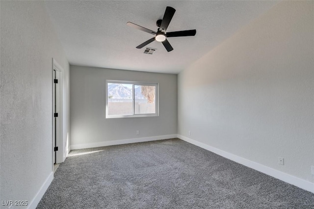 empty room with a textured ceiling, ceiling fan, and carpet