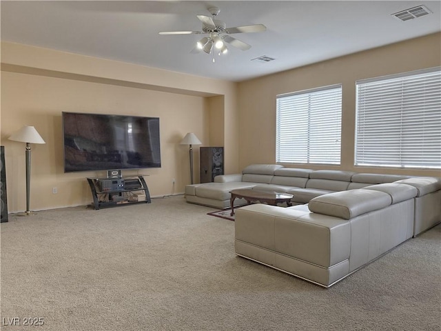 carpeted living room with ceiling fan