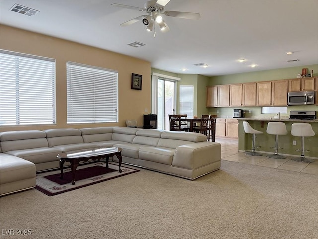 carpeted living room featuring ceiling fan