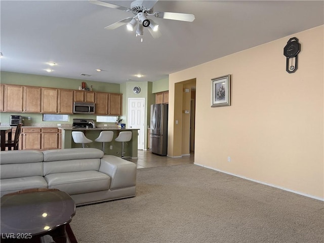 living room featuring light carpet and ceiling fan