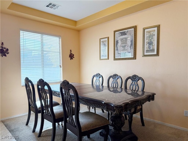 dining space with a raised ceiling