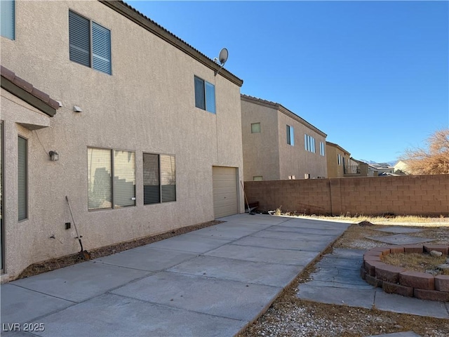 back of house with a garage and a patio