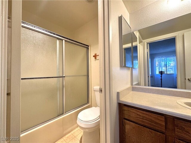 full bathroom with toilet, vanity, tile patterned flooring, and enclosed tub / shower combo