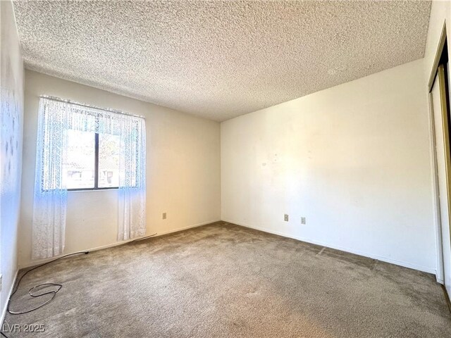 empty room featuring carpet floors and a textured ceiling