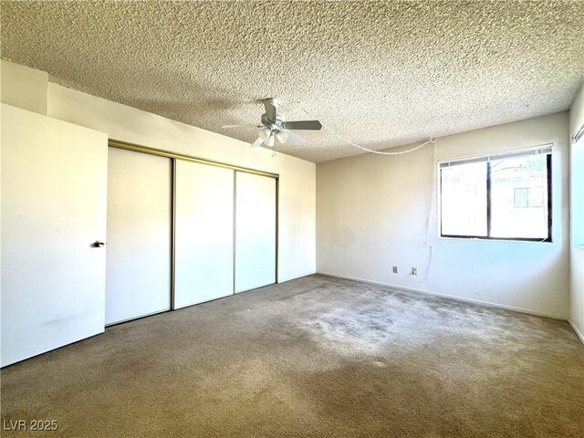 unfurnished bedroom featuring ceiling fan, a textured ceiling, a closet, and carpet