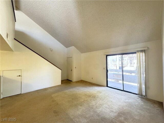 unfurnished living room featuring a textured ceiling, light colored carpet, and high vaulted ceiling