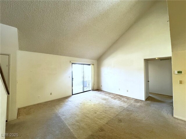 carpeted spare room featuring high vaulted ceiling and a textured ceiling